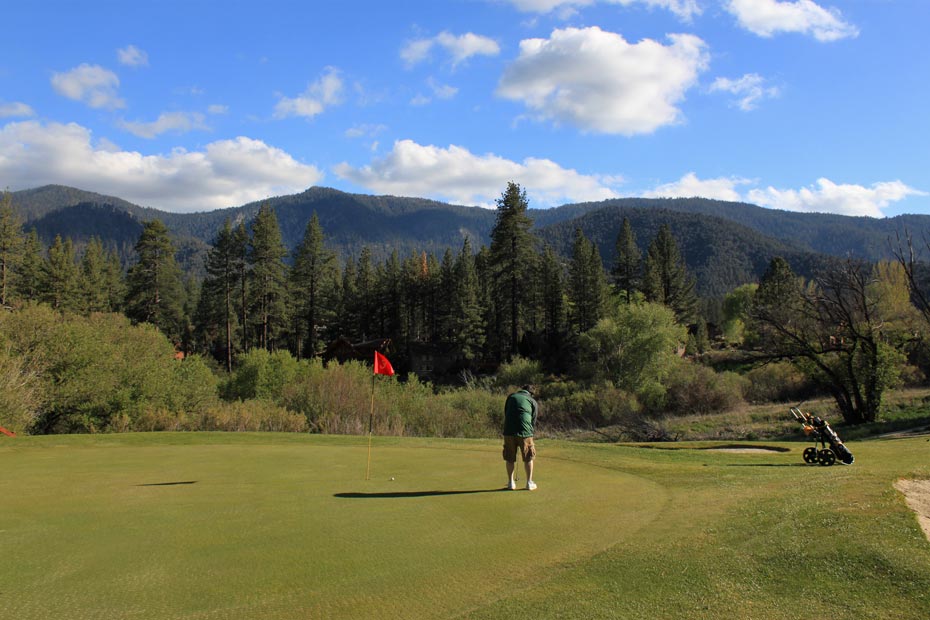 Golfer on putting green at Pine Mountain Club golf course