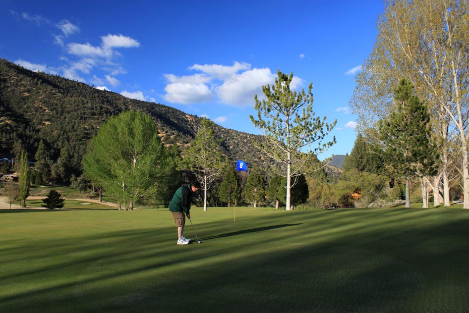 Golfer putting on green at Pine Mountain Club golf course