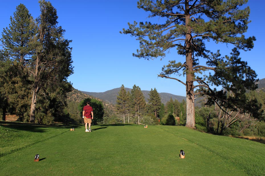 Golfer in red shirt at tee box at Pine Mountain Club golf course