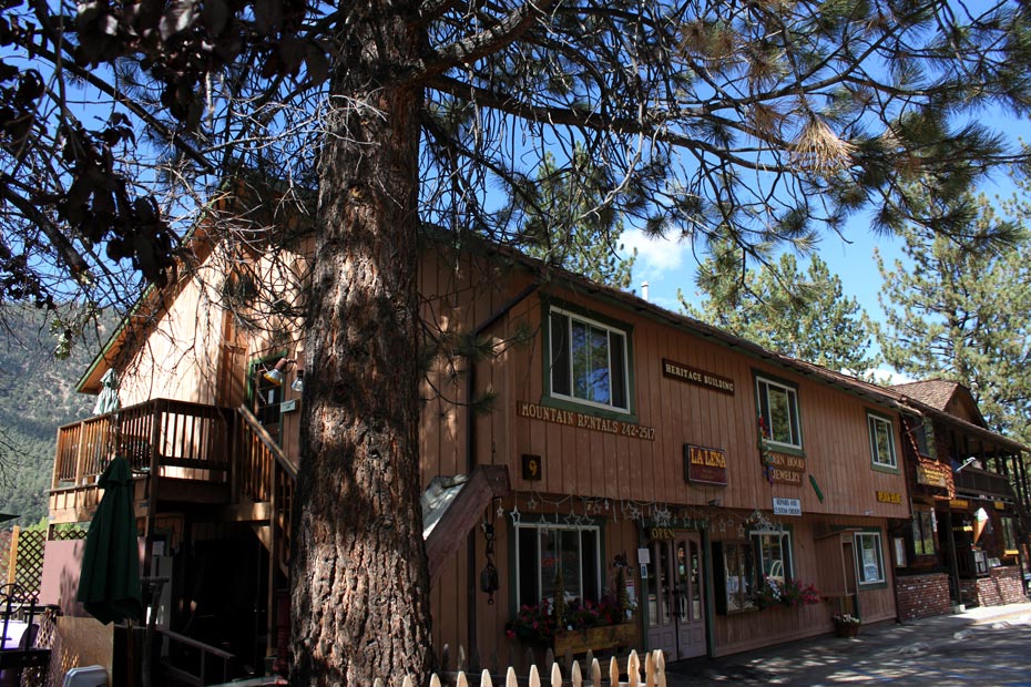 Two-story commercial building in Pine Mountain Club village with trees and balconies